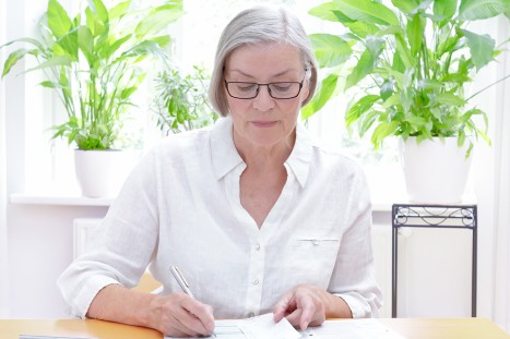 Ältere Dame bearbeitet Unterlagen